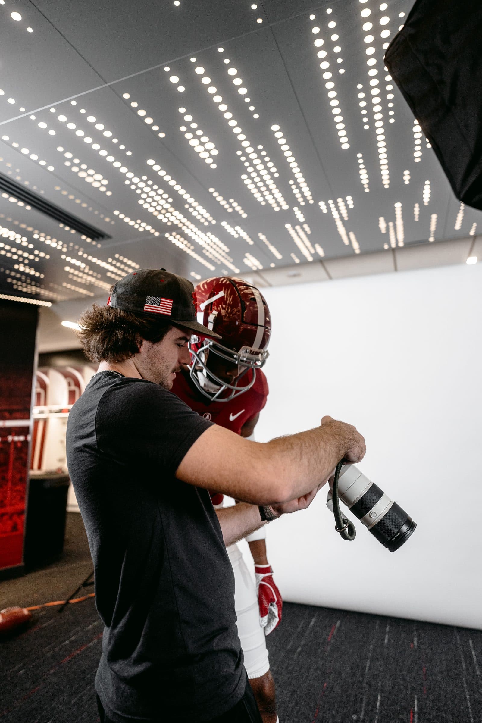 Rowe with a camera on set filming an Alabama football player