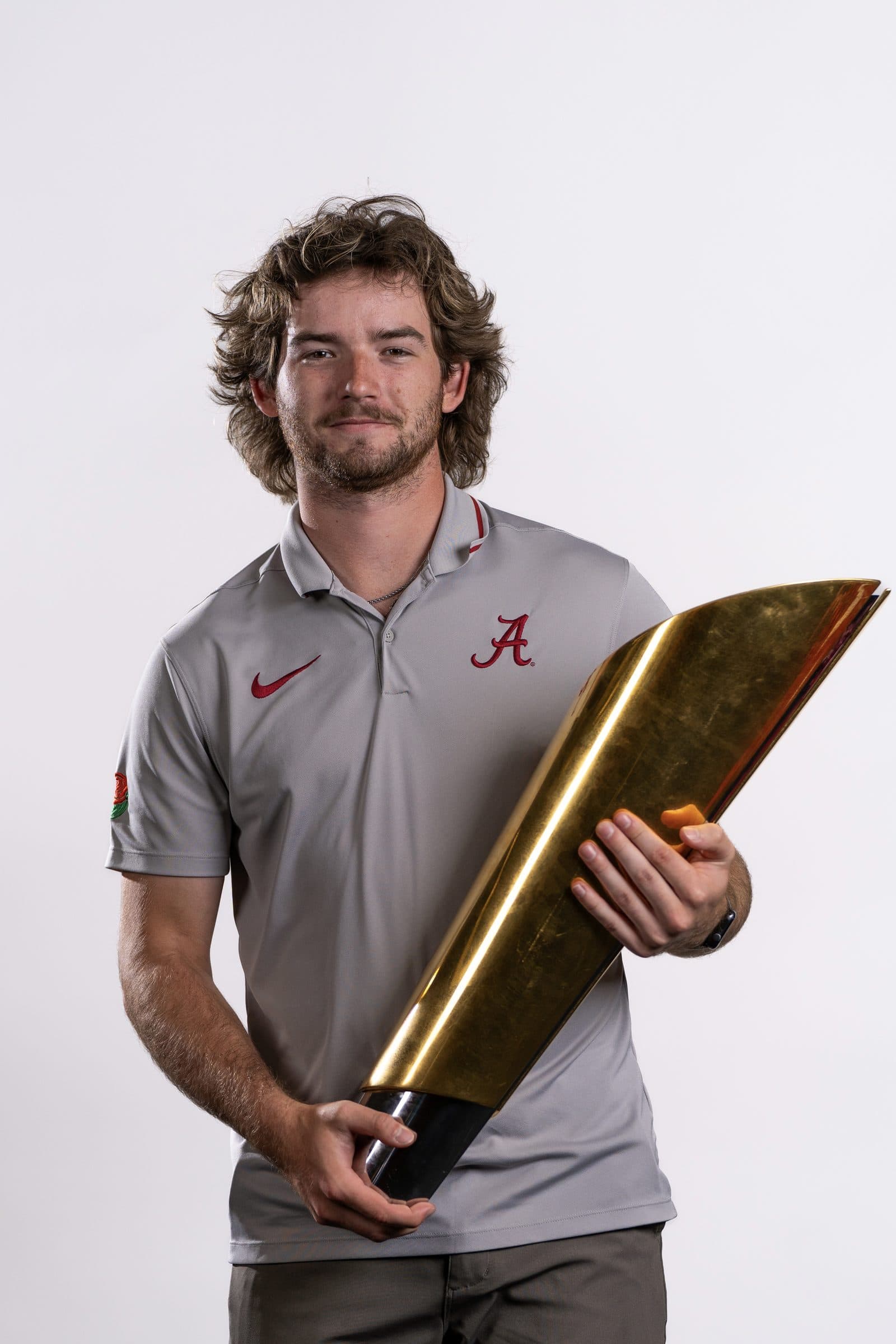 Rowe holding the national championship trophy in an Alabama polo